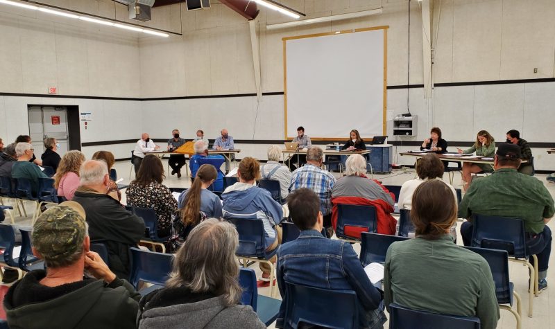 People sitting in chairs listen to a presentation