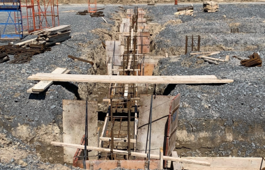 Construction de la fondation de la nouvelle concession Laplante à l’extérieur, composée de bois et de métal dans un troue creusé entouré de roches.