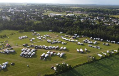 A drone shot of a field full of RVs and campers for a music festival.