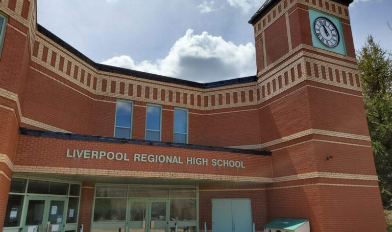 The outside of the brick building of Liverpool Regional High School on a sunny day