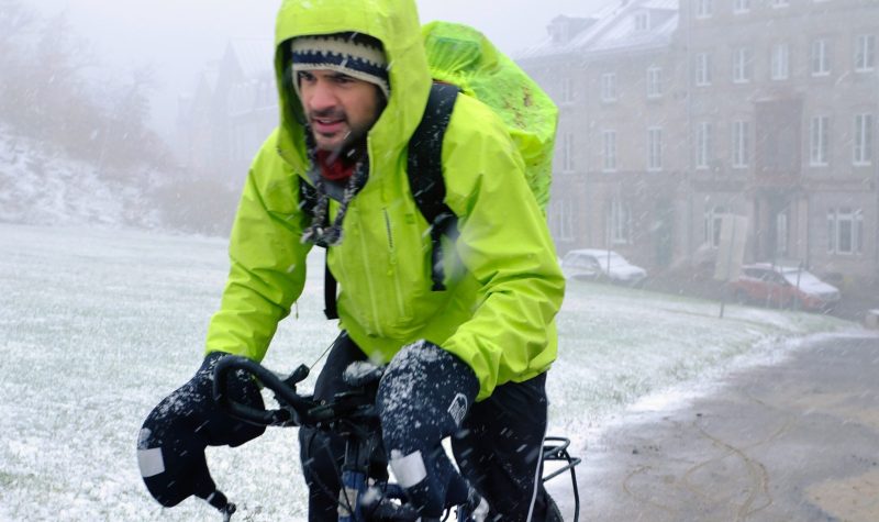 homme sur un vélo sous une tempête de neige