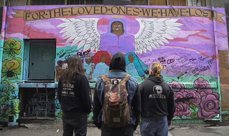 People looking at mural called For the Loved Ones We Lost
