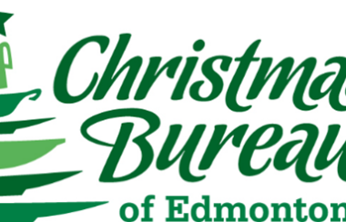 Sign in green of a Christmas tree on left side and Christmas Bureau of Edmonton on right side