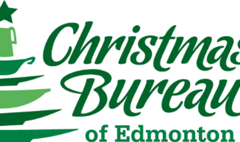 Sign in green of a Christmas tree on left side and Christmas Bureau of Edmonton on right side