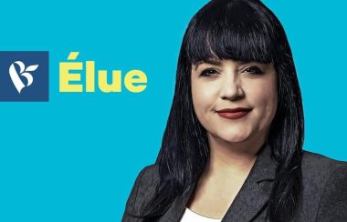 Affiche de la candidate Marilène Gill du Bloc Québécois. Dame aux cheveux noirs, rouge à lèvre rouge foncé, veston gris foncé et chandail blanc sur fond bleu ciel.