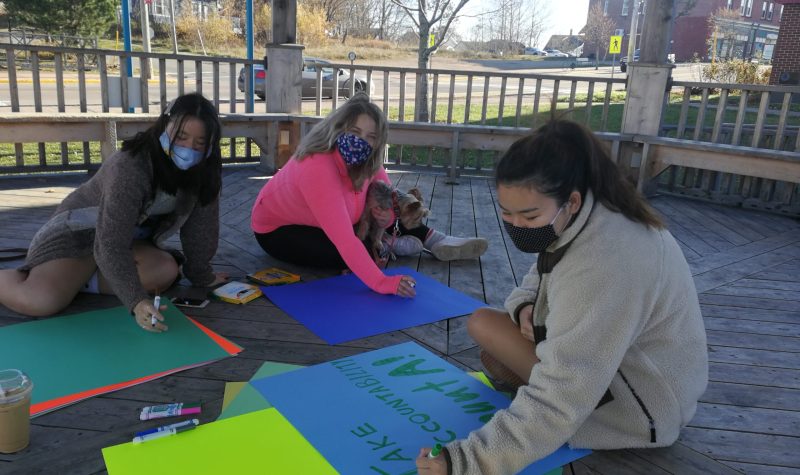 Molly Park, Michelle Roy, and Seena Katayama make posters in preparation for Thursdays solidarity protest over sexual assault handling at Mount Allison University. Photo: Erica Butler
