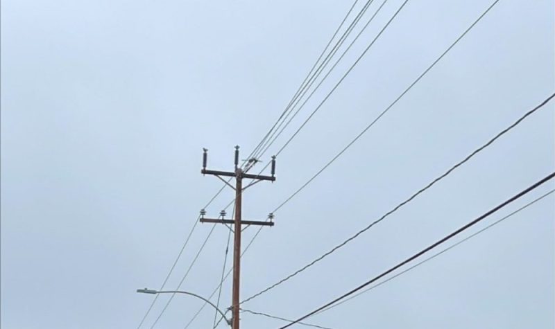 Un poteau de distribution entouré de fil électrique