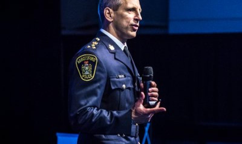 Abbotsford Police Chief Mike Serr making a speech with a microphone in his hand.