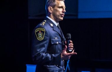 Chief Constable Mike Serr of the Abbotsford Police Department giving a speech in front of a crowd.