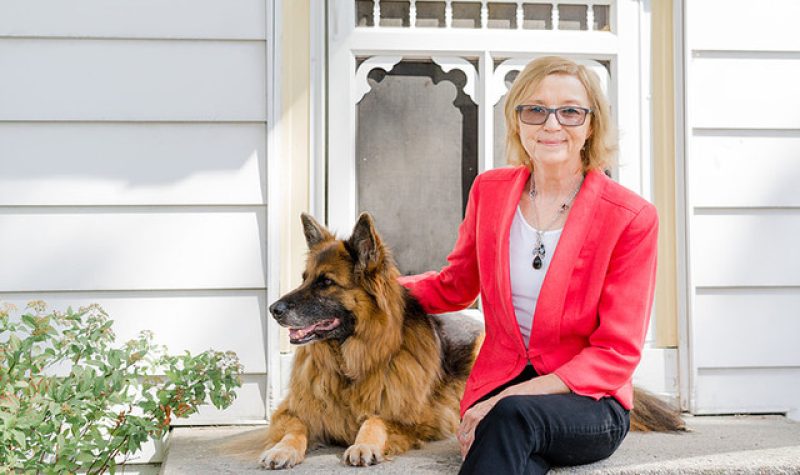 Michelle Nadon sitting on the porch with her German Sheppard