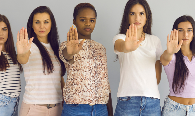 Seis mujeres poniendo su mano al frente en se;al de detener algo