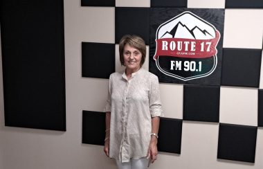 Femme portant une chemise blanche se tient debout dans le studio de la Radio des Hauts-Plateaux.