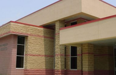 On peut voir une partie du bâtiment de l'École secondaire catholique Nouvelle-Alliance de Barrie. Le bâtiment est en briques beiges et roses.