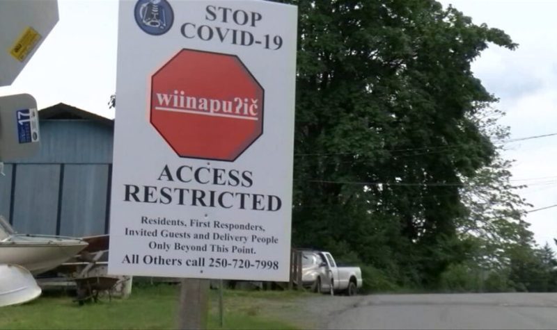 A white sign with a stop sign on it outside of a First Nation reserve.