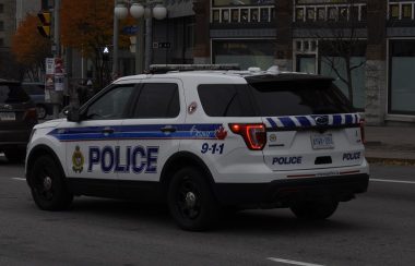An Ottawa Police vehicle is seen from behind, idling on a busy street in downtown Ottawa.