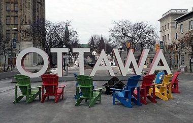 Des chaises multicolores entourent l'enseigne d'Ottawa située sur la rue York. Photo: heritagedowntowns.com