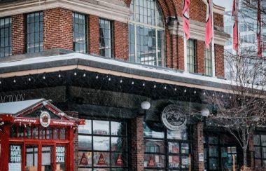 A photo displaying a 2-storey red brick building in the Byward Market in Ottawa during the winter time.