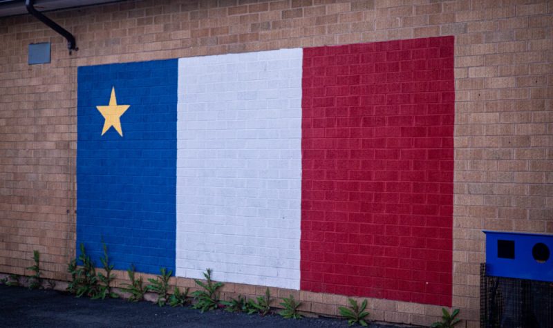 Le drapeau acadien peint sur le mur de l'ancienne école anglophone devenue francophone. Photo : Valentin Alfano