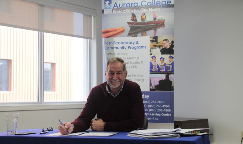 Assis à son bureau, le président du Collège Aurora, Andy Bevan.