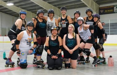 Eleven members of PARD pose for a team photograph in their roller derby protective gear during a practice.