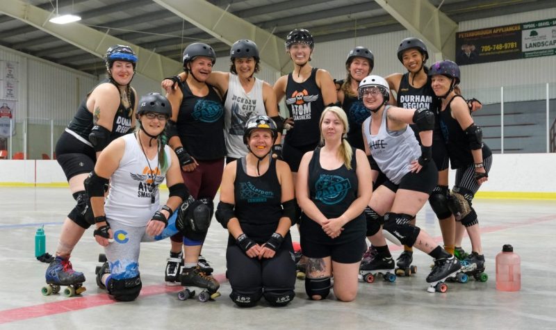 Eleven members of PARD pose for a team photograph in their roller derby protective gear during a practice.