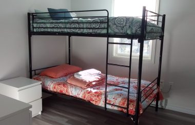 A bedroom with a bunk bed, in a shelter.
