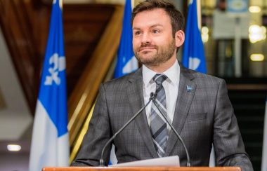 Monsieur Paul St-Pierre Plamondon, chef du Parti Québécois, vêtu d'une veste grise et cravate sur chemise bleue