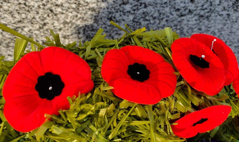 A close up of red poppies on a Remembrance Day wreath