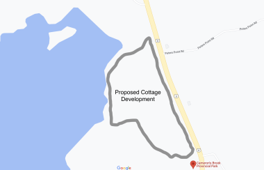 A google map showing an outline designating a proposed development next to a lake and a highway.