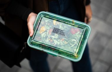 gros plan sur une boite en plastique transparente à travers laquelle on distingue de la nourriture à l'intérieure