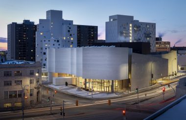 Le centre d'art situé au centre-ville, le ciel sombre, les lumières à l'intérieur sont allumées.