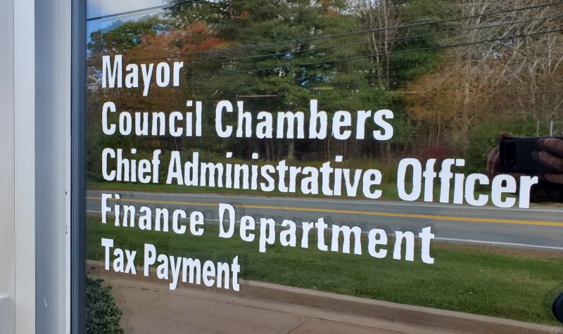 A glass door with letters which say 'Chief Administrative Officer, Finance Department, Tax Payment'