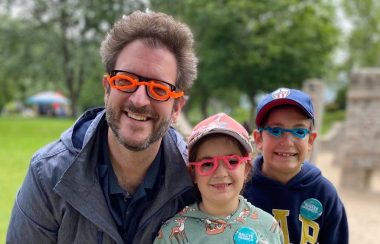 Un homme avec deux enfants portant des lunettes en plastiques