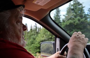 Le maire et préfet Randy Jones est photographié à bord de sa camionnette. Il porte un t-shirt rouge. En arrière-plan, on voit la forêt.
