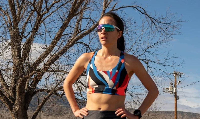A woman with sunglasses on in running clothes