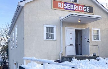 Photo of a house with a sign reading “Risebridge” on it with snow on the ground.