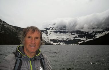 Ron Dart Standing in front of a river and mountains