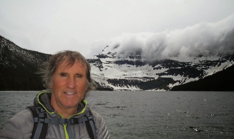 Ron Dart Standing in front of a river and mountains