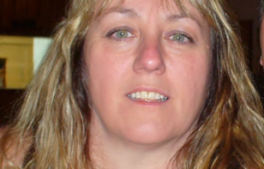 A headshot of Rosalee Gravelle with blonde hair and a black and white top.