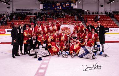 The South Alberta Hockey Academy lay on center ice, posing with the championship they just won at the Circle K Classic