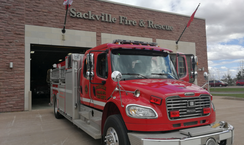 A red fire truck is parked outside of the Sackville Fire and Rescue building.