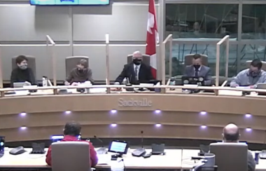 Men and women sitting at a council table, facing the camera.