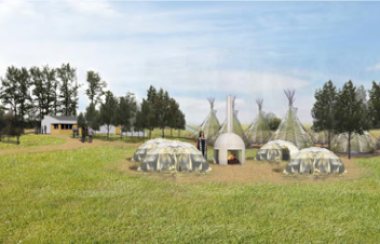 A rendering of the Sacred Land project. The image shows a green field with several white structures, including a central fire pit.