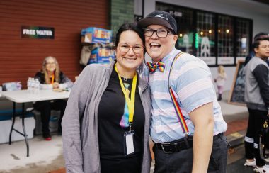 A press photo of Teri Westerby at a PRIDE event in Chilliwack posing with a member of the Chilliwack PRIDE society