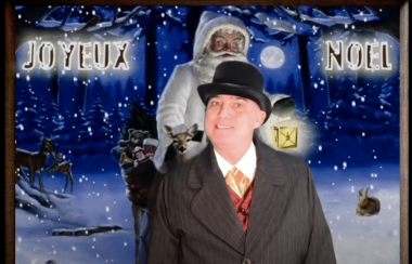 Robert en habillé en manteau noir et chapeau haut de forme avec un arrière-plan d'un Noël blanc avec le Père Noël.
