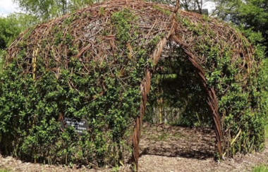 Pictured is the poem cocoon. It is a round structure made out of branches and willow trees.