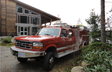 A red fire truck parked outside a community building.