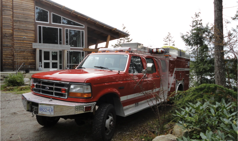 A red fire truck parked outside a community building.