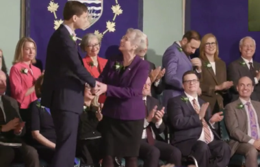 katrina conroy shakes hands with bc's premier david eby in front of the rest of the provincial cabinet