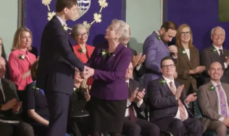 katrina conroy shakes hands with bc's premier david eby in front of the rest of the provincial cabinet